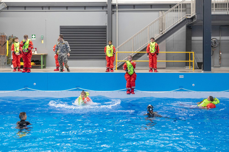 Group of students in the pool wearing yellow lifesaving vests