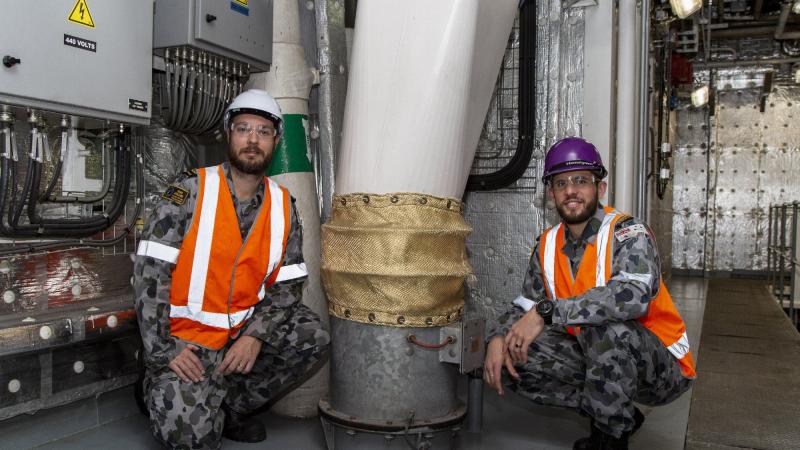 Petty Officer Nathan Austin, left, and Lieutenant Ryan Webb inspect one of the ventilation fans on board HMAS Adelaide at Garden Island, Sydney. Photo: Able Seaman Sittichai Sakonpoonpol