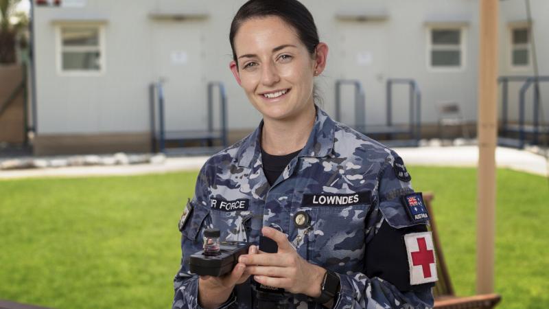 Flight Lieutenant Chloe Lowndes with a water sample for testing at the ADF’s main operating base in the Middle East. Photo: Corporal Tristan Kennedy