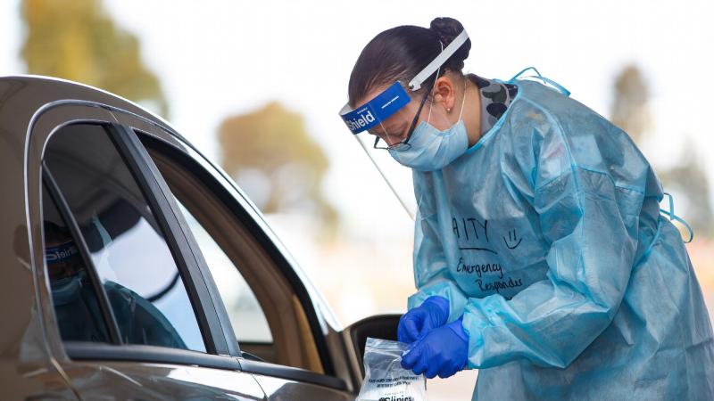 Able Seaman Maritime Logistics Chef Caitlyn Shrubsole tests a member of the public for COVID-19 at the Casey Fields COVID-19 community drive-through screening clinic in Victoria. Photo: Private Dustin Anderson