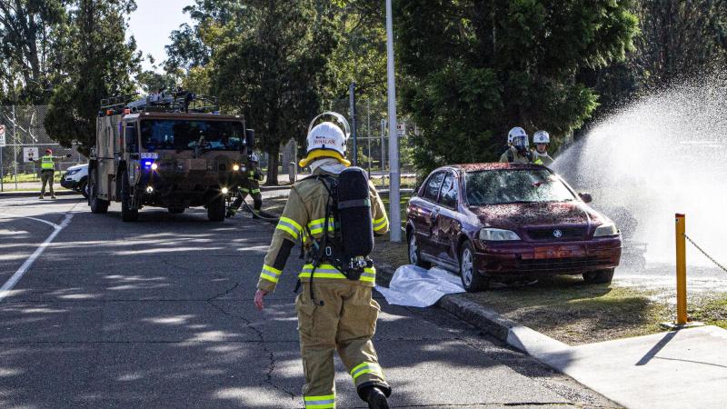 Corporal Justin Whalan monitors personnel as they extinguish the simulated fire during the motor-vehicle accident exercise held at RAAF Base Richmond, NSW. Photo: Sergeant Greg O’Neill