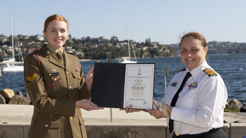 Director Fleet Health Captain Amanda Garlick, right, presents a course certificate to Corporal Naomi Lang during the ceremony at HMAS Penguin, Sydney.