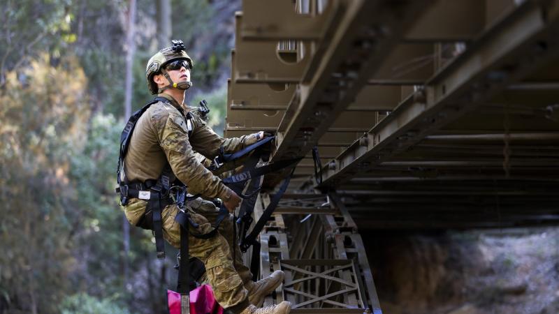 Lieutenant James Bonney attaches simulated explosives to a bridge during the final field phase of the Engineer Regimental Officer Basic Course. Photo: Sergeant Ray Vance