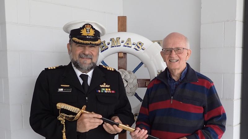 Commanding Officer HMAS Moreton Commander Gerald Savvakis accepts the ceremonial sword from Ian McGilvray during a ceremony at Morton.