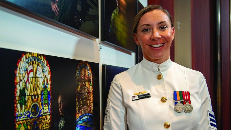 Then Petty Officer Jessica Buley stands beside her portrait in the ‘thank you for your service’ photographic exhibition in the Anzac Memorial, Hyde Park, Sydney last year. Photo: Chief Petty Officer Cameron Martin