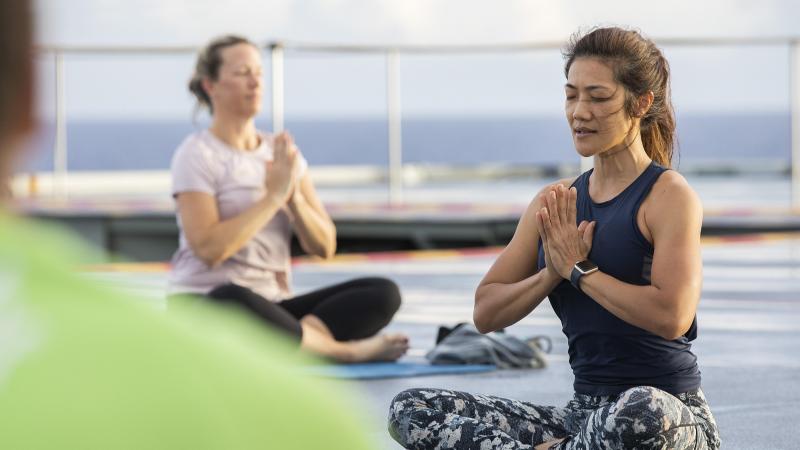 Able Seaman Chutima Luerach conducts a yoga class at sea on board HMAS Canberra. Photo: Petty Officer Tom Gibson