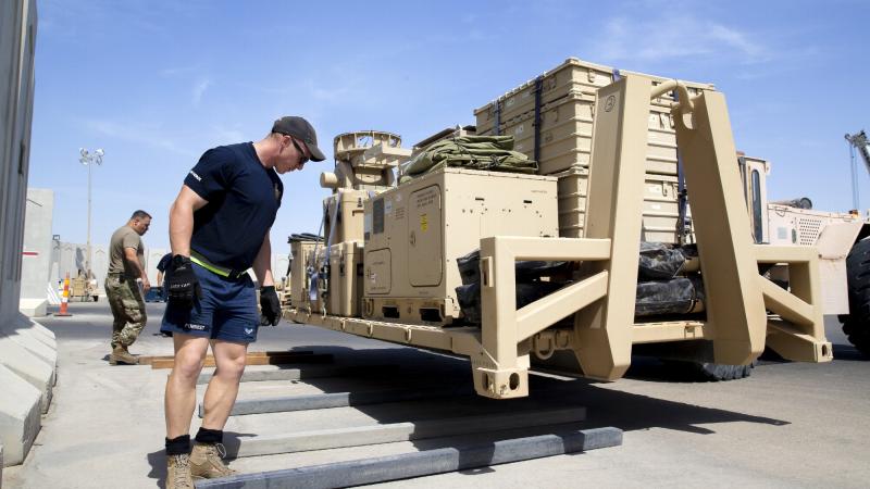 Corporal Christiaan Forrest works with United States Air Force personnel to pack up ADF equipment at Camp McNamara VC in the Middle East. Photo: Corporal Tristan Kennedy