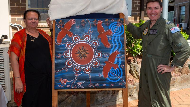 Leanne Watson presents Commanding Officer Air Mobility Training and Development Unit Wing Commander Cameron Clark with her artwork. Photo: Corporal Dan Pinhorn