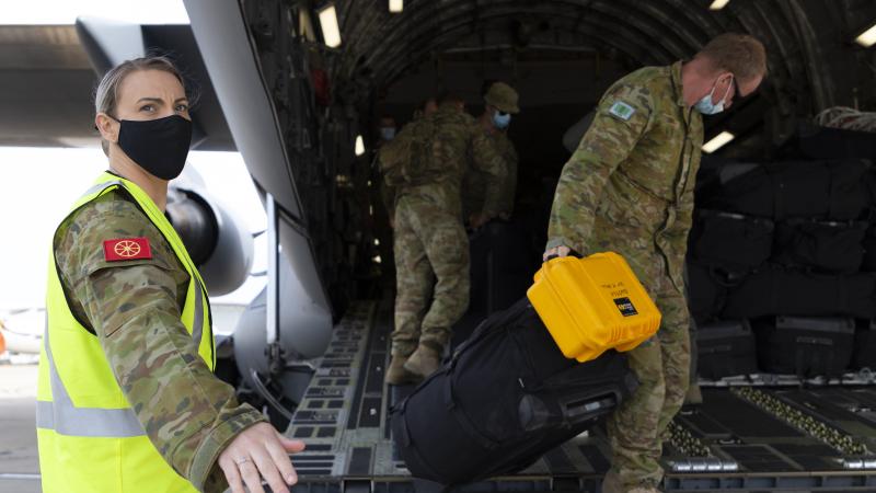 Private Caroline Walker-Campbell helps soldiers disembark a RAAF C-17A Globemaster during operation COVID-19 Assist. Photo: Sergeant Kirk Peacock