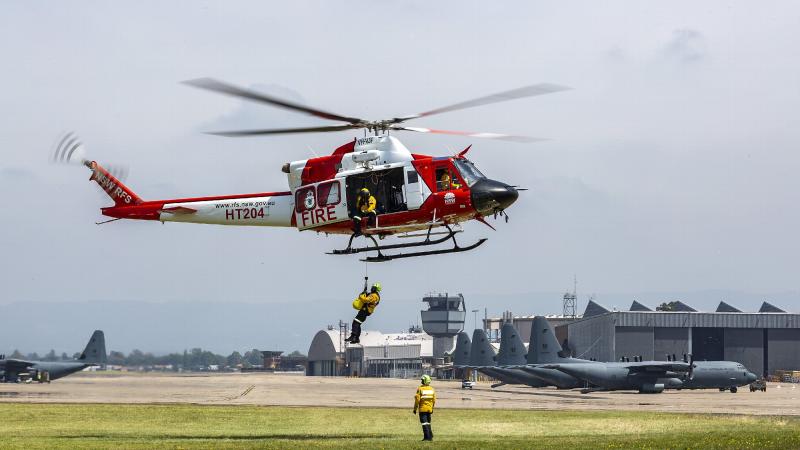 A NSW Rural Fire Service Bell 412 helicopter demonstrates its rescue capabilities at RAAF Base Richmond. Photo: Corporal Dan Pinhorn