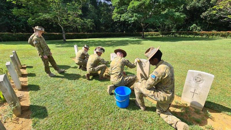 Members of 130th rotation of Rifle Company Butterworth clean the gravestones of fallen Commonwealth service personnel at the Taiping War Cemetery, Malaysia. 