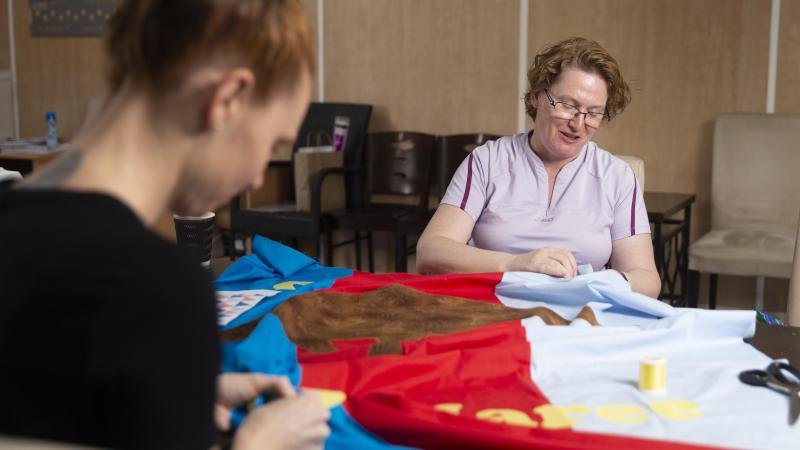 Sergeant Jodie Mitchell, left, and Squadron Leader Andrea Fullick work on the quilt for Aussie Hero Quilts' Jan-Maree Ball at Australia’s main operating base in the Middle East region. Photo: Corporal Tristan Kennedy