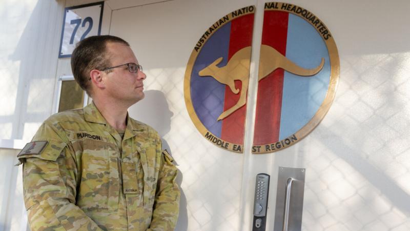 Craftsman Cameron Purdon with his handmade logo on the doors of Headquarters Joint Task Force 633 at Australia’s main operating base in the Middle East region. Photo: Major Kris Gardiner 