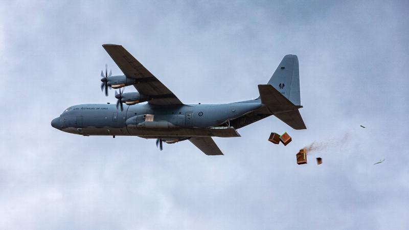 Bundles of livestock fodder fall from a No. 37 Squadron C-130J Hercules during a trial at Londonderry, NSW. Photo: Corporal David Said