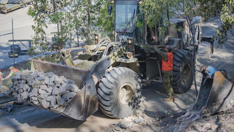 Loader operator Sapper Ray Casten and Sergeant Jesse Hall, both of104 Construction Squadron, 11the Engineer Regiment, work on a culvert repair at Enoggera Close Training Area. Sergeant Adrian Phoebe
