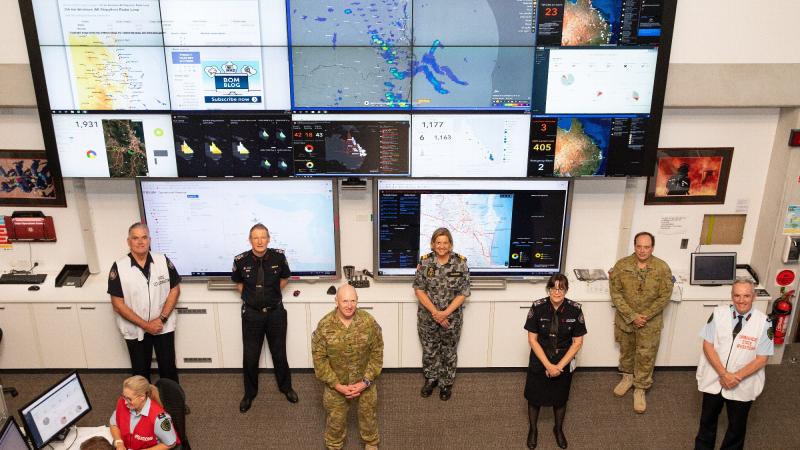 Lieutenant General John Frewen and Rear Admiral Sarah Sharkey, third and fourth from left, with ADF and Queensland emergency services representatives at the State Disaster Coordination Centre in Brisbane. Photo: Corporal Jesse Kane