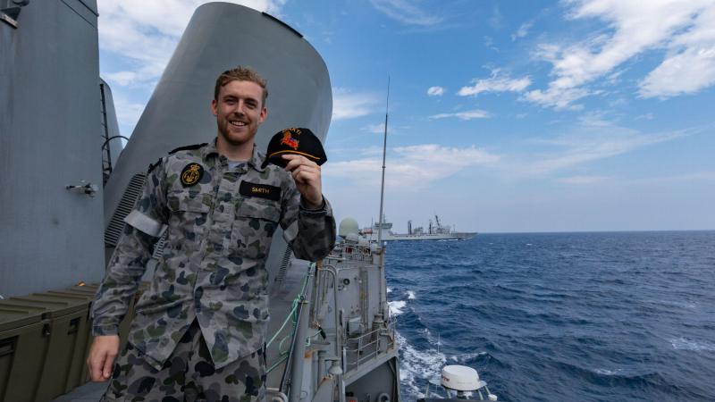 Able Seaman Charlie Smith, from HMAS Ballarat, with a cap gifted from a sailor on board INS Shakti. Photo: Leading Seaman Shane Cameron