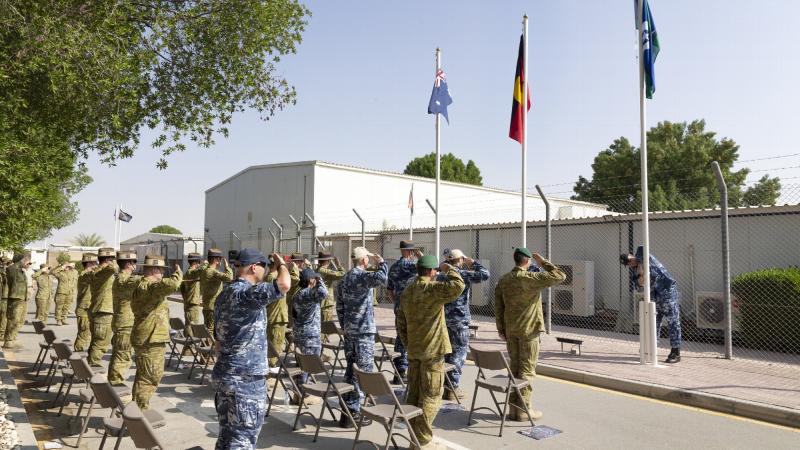 Members of Joint Task Force 633 salute the flags during a NAIDOC Week flag-raising ceremony at Australia’s main operating base in the Middle East. Photo: Corporal Tristan Kennedy