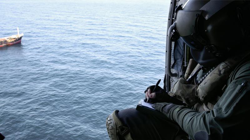 Leading Seaman Aircrewman Brad Firkin collects information on a vessel of interest from HMAS Arunta’s MH-60R Seahawk helicopter during Operation Argos. Photo: Leading Seaman Jarrod Mulvihill