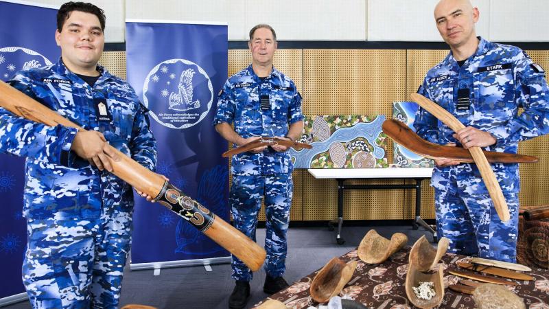 Air Force Officer Cadet Jaylin Lilley, left, explains the Indigenous artefacts on display at RAAF Base Williamtown to Group Captain Peter Cluff and Wing Commander John Stark. Photo: Corporal Brett Sherriff