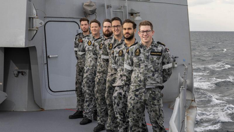  HMAS Arunta's marine technician fabrication team in front of the forecastle door the team repaired. Photo: Leading Seaman Jarrod Mulvihill