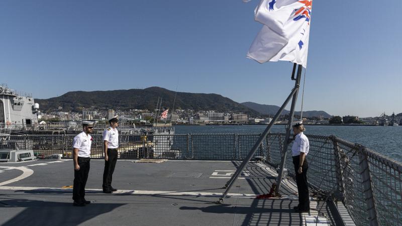 Members of HMAS Arunta's ship's company stand at attention during a Remembrance Day ceremony while alongside Sasebo Naval Base, Japan. Photo: Leading Seaman Jarrod Mulvihill 