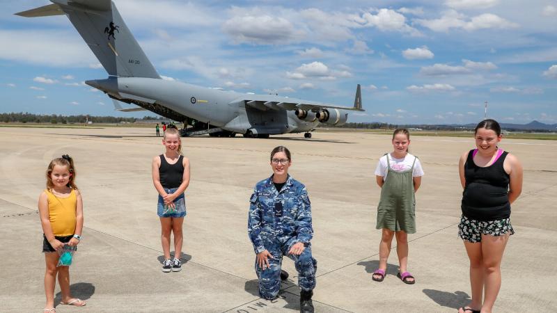 Leading Aircraftwoman Paige Madden, from No. 23 Squadron, with local Indigenous students Macy, left, Keira, Paige, Gabby and Addy on the flight line at RAAF Base Amberley. Photo: Corporal Nicci Freeman