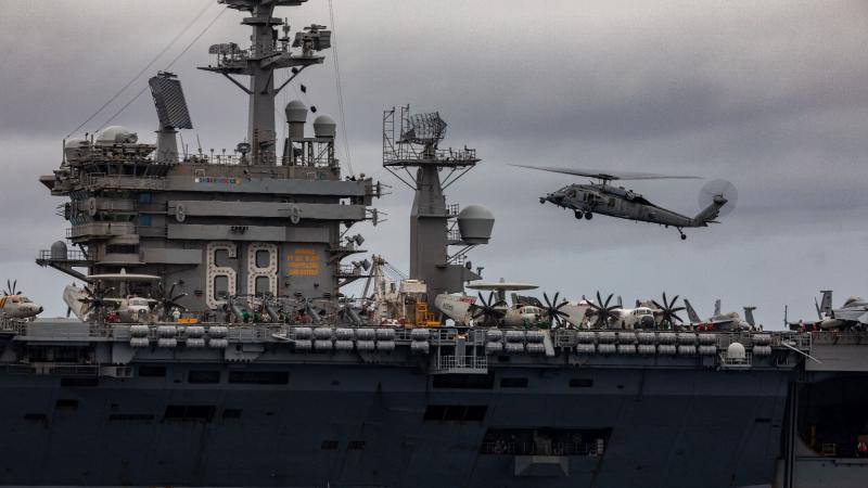 An MH-60S helicopter approaches USS Nimitz flight deck during a passage exercise with HMAS Ballarat in the Indian Ocean. Photo: Leading Seaman Shane Cameron