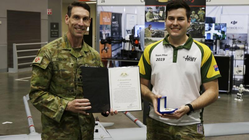 Commander 6 Brigade Brigadier Michael Ascough, left, presents Private Mackenzie Togo with an Army gold commendation. 