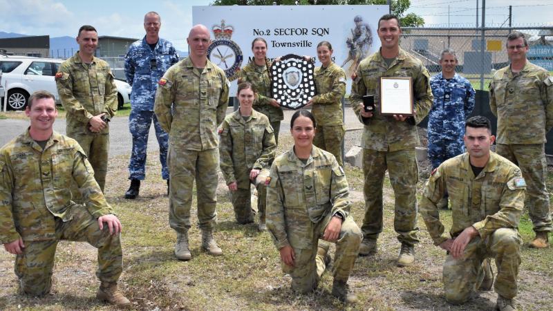Officer Commanding No. 95 Wing Group Captain Mark Larter presents the Lady Hannah Shield to No.2 Security Forces Squadron in Townsville. 