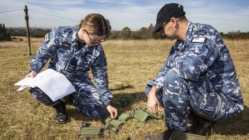 Leading Aircraftwoman Kate Kershaw and Leading Aircraftman Jordan Hopkins erect an aerial for the UXO TrackS system trial. Photo: Sergeant Shane Gidall