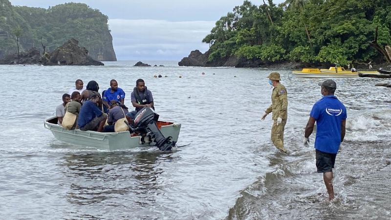 A soldier prepares to help survivors as they approach a beach in Ambae after being rescued from a sinking ship in Vanuatu. Photo: Warrant Officer Class 2 Paul Farrell