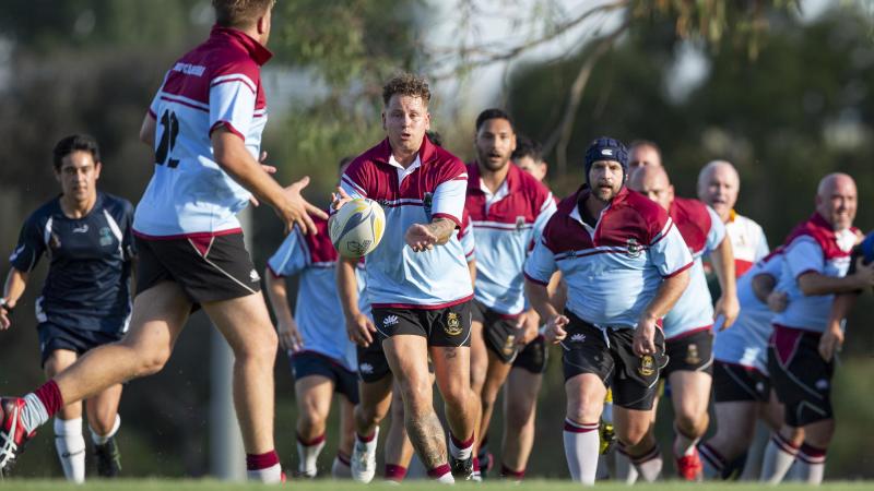 HMAS Canberra player Able Seaman Marine Technician Blake Simpkins offloads the ball during a match against the ACT Vets at Kapyong Oval, Canberra. Photo: Petty Officer Lee-Anne Cooper