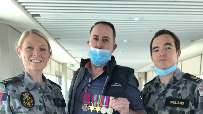 Leading Seaman Alisha Mosely and Leading Seaman Alan Williams with Terrance Quinn, the great-nephew of Ordinary Seaman Edward 'Teddy' Sheean, VC, and the replica medals at Brisbane Airport.