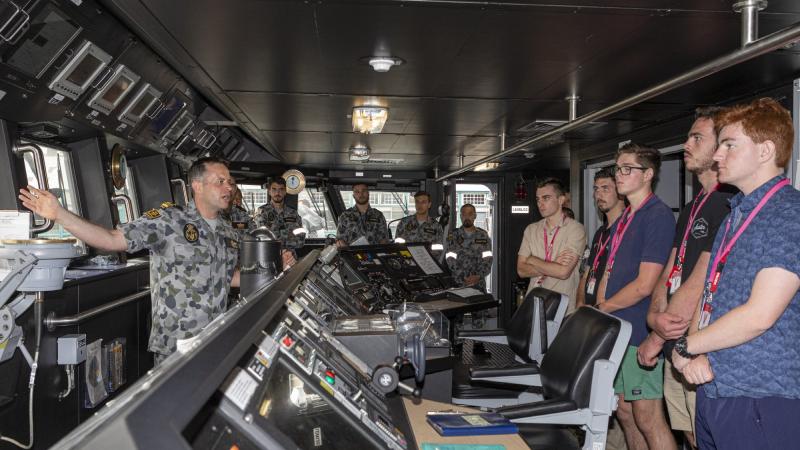 Weapons Electrical Engineering Officer in HMAS Brisbane Lieutenant Commander Alistair French with University of Newcastle engineering students who toured Navy establishments in Sydney.
