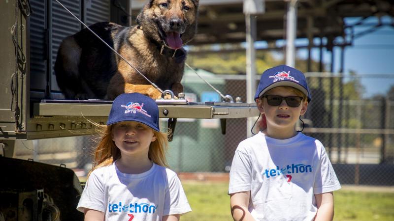 The 2020 Little Telethon Stars, Nora Holly and Eamon Doak, with military working dog Xeren during a visit to RAAF Base Pearce in Western Australia. Photo: Leading Seaman Richard Cordell 