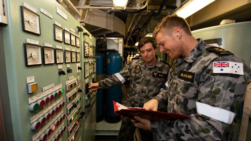 Marine technicians Able Seaman Daniel Ryan and Petty Officer Rhys Blackaby conduct routine maintenance on HMAS Ballarat during an Indian Ocean deployment. Photo: Leading Seaman Shane Cameron