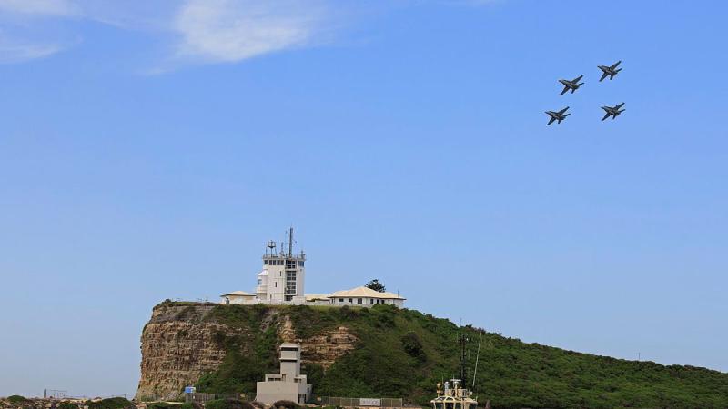 A formation of four F/A-18A/B Hornets over the lighthouse at Nobbys Beach in Newcastle. Photo: Corporal Brett Sherriff