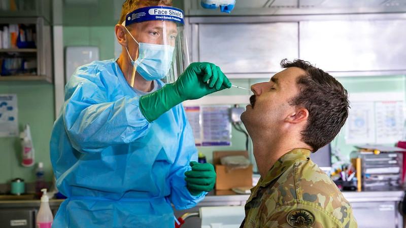 Lieutenant Nicholas Ilijas conducts a COVID-19 test in HMAS Adelaide as part of the COVID-19 safety protocols for Operation Fiji Assist. Photo: Corporal Dustin Anderson