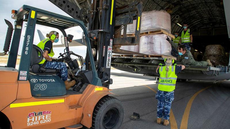 Forklift driver Leading Aircraftwoman Sophie Berthelot, Leading Aircraftwoman Angelina Prountzos and Warrant Officer Adam Olding unload fire retardant from an Air Force C-17A Globemaster at Busselton airport. Photo: Leading Seaman Richard Cordell