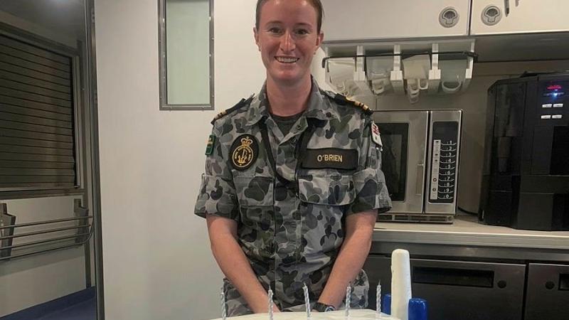 Commanding Officer Australian Defence Vessel Cape Inscription Lieutenant Commander Jessica O'Brien with a cake made by the catering crew. The crew was awarded the Silver Platter Award ─ Minor War Vessel.
