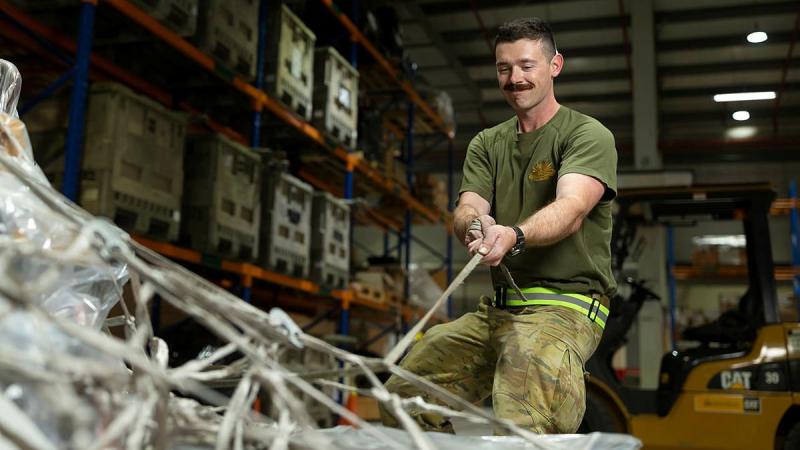 Private Mason Tessier secures cargo pallets in the warehouse of the ADF's main operating base in the Middle East, Camp Baird. Photo: Corporal Tristan Kennedy