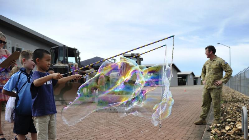Children of soldiers of the 1st Combat Engineer Regiment make bubbles during the regiment's family day.