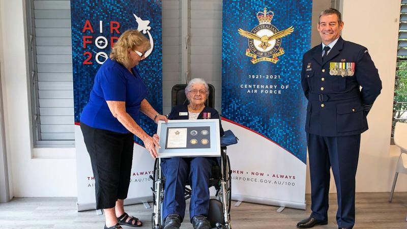 Wilma Ayles, centre, supported by her daughter Evelyn Schuetze, receives an Air Force 2021 memento from Senior ADF Officer Amberley Group Captain Iain Carty at Cooroy, Queensland. Photo: Leading Aircraftwoman Emma Schwenke