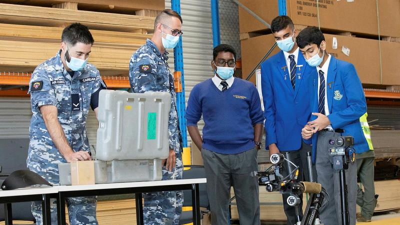 Leading Aircraftman Chris Carrigan, left, and Leading Aircraftman Jordan Hopkins demonstrate a vehicle used to detect Improvised Explosive Devices to Patrician Brothers students Amarjith Ajith, Agam Gujral and Damien Sinha, Photo: Corporal Kylie Gibson