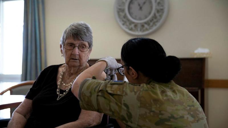 ADF medic Private Christie Rayner, from the Joint Health Unit - North Queensland, administers the COVID-19 vaccine to Lorna Pollack at the Blue Care aged-care facility in Ingham, Queensland.