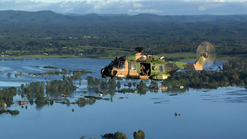 A Royal Australian Navy MRH-90 Taipan multirole helicopter fly's over flood affected waters during the ADF support to Operation NSW Flood Assist.