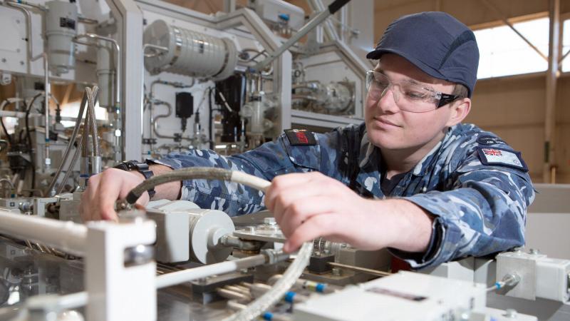 Aircraftman Bailey Gray sporting a bump cap while undertaking maintenance checks on the GENFLY 1 training aid at the RAAF School of Technical Training, RAAF Base Wagga. Photo: Corporal Kylie Gibson