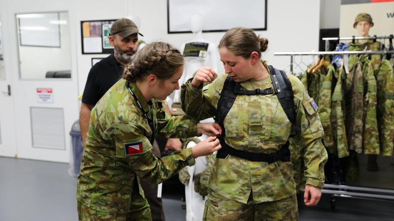 Lance Corporal Rebecca Baxter from the 4th/19th Prince of Wales Light Horse Regiment adjusts the prototype female heavy-webbing harness and belt on Private Jessica Russell from the 8th/7th Battalion, Royal Victoria Regiment. Photo: Captain Kristen Cleland