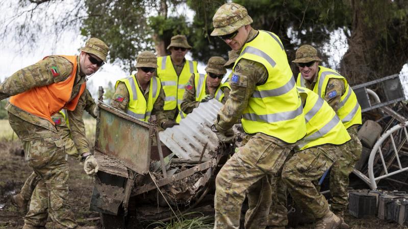 Soldiers deployed on Operation NSW Flood Assist help community members remove debris from flood damage in Taree, NSW. Photo: Corporal Sagi Biderman 